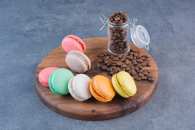 咖啡豆不同颜色的通心粉饼干和咖啡豆放在木板上糖果美味食品