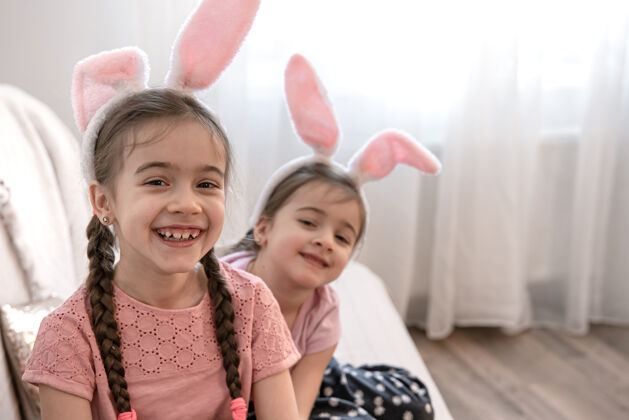 孩子小可爱的姐妹们在兔子耳朵靠近童年兔子复制空间