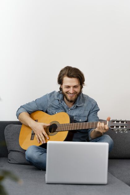 放松带吉他的满脸笑容的人室内男性演奏