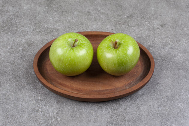 成熟的两个新鲜的绿色苹果放在厨房的木板上素食有机营养