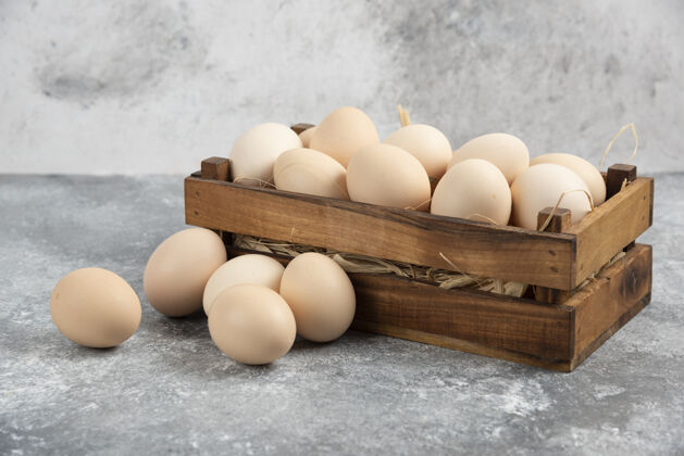 烹饪大理石表面的有机生鸡蛋木盒生的食物鸡蛋
