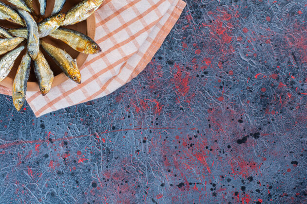 小吃把咸鱼干放在一块粘土板上 背景是深色的顶视图鱼海鲜