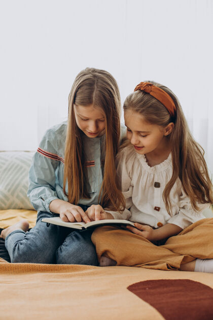 年轻女孩朋友一起在家看书思考学龄前儿童女性