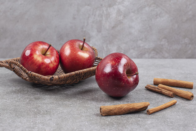 成熟的两个红苹果放在木筐里 里面有肉桂条苹果新鲜小吃