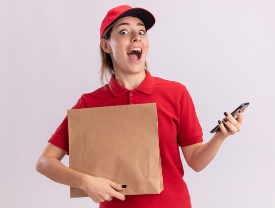 表情一个穿着制服的年轻漂亮的女送货员拿着一个纸包 把电话隔在白色的墙上人姿势站