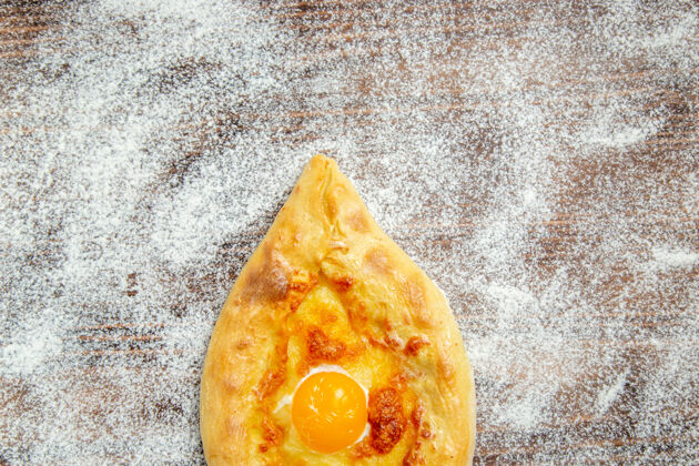 桌子顶视图新鲜的烤面包与煮熟的鸡蛋和面粉在棕色的桌子上面团烤面包粉鸡蛋顶部景观可食用的水果