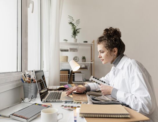 室内中等身材的女人用笔记本电脑工作水平室内室内设计