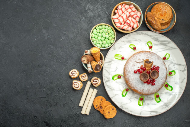 顶部糖果的俯视图一个带有浆果的蛋糕 绿色的沙司饼干 糖果糖果菜肴早餐