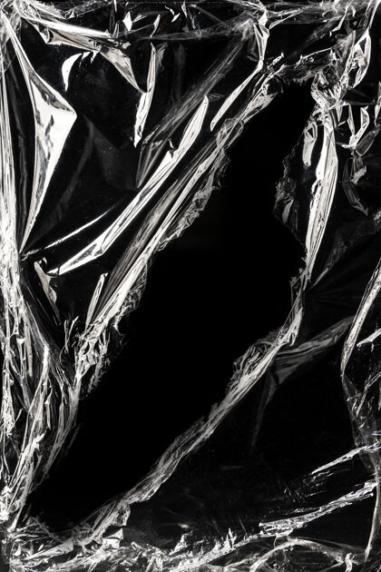 封面黑色背景上的褶皱塑料包装纹理废物效果透明
