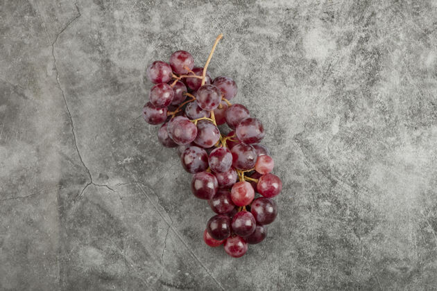 美味大理石表面有一簇簇新鲜成熟的红色葡萄食物果皮红色