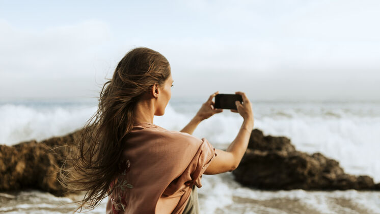 度假拍大海照片的女人女人相机捕捉
