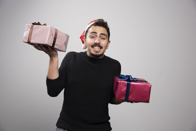 盒子一个戴着圣诞老人帽子的笑脸男人 手里拿着新年礼物男人姿势年轻人