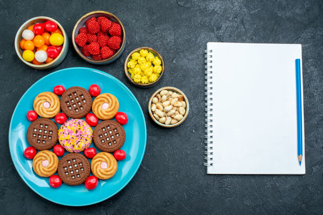 盘子顶视图不同的糖饼干与糖果的灰色表面糖糖果甜饼干饼干托盘生的晚餐