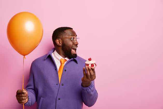 青少年快乐震惊的美国黑人男子站在派对气球和甜点胡须高兴奇迹