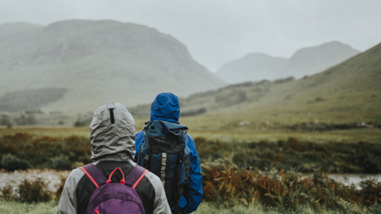 小路一对夫妇在高原的雨中跋涉自然背包高山