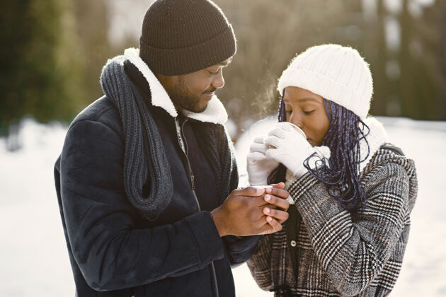 黑色人们走在外面冬天非洲夫妇带咖啡男人女孩拥抱