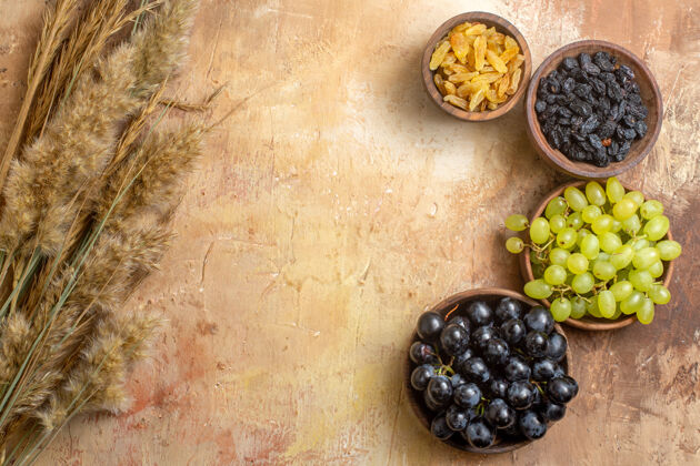 碗顶视图葡萄葡萄干在碗小穗在桌子上浆果蓝莓葡萄