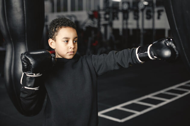 活动年轻勤奋的拳击手学习拳击孩子在体育中心孩子开始了一个新的爱好童年运动装拳击