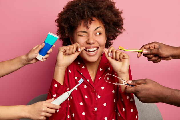 治疗口腔卫生和牙齿护理概念卷发女人用牙线刷牙 用清洁剂清洁舌头 使用牙刷和牙膏 在家里摆姿势刮刀牙科化妆品