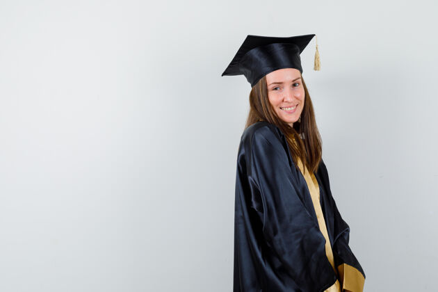 女性女毕业生穿着学院服站在那里 看起来很开心肖像长袍成就
