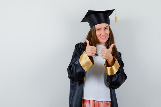 学术毕业的女人穿着休闲服 穿着制服 竖起大拇指 看上去很高兴正面图人学位前夫