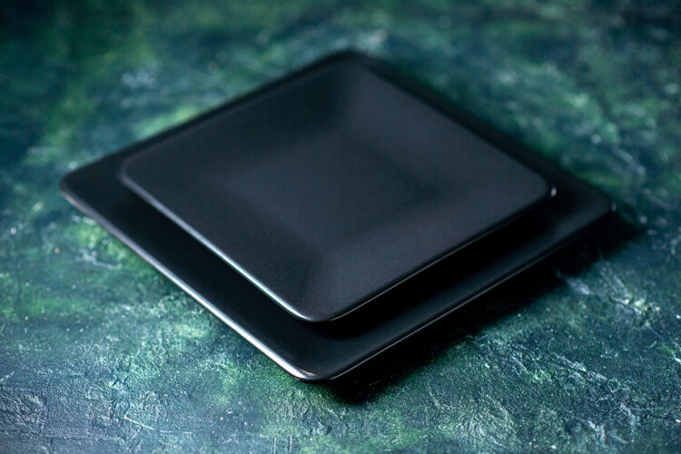 晚餐前视图深蓝色背景上的黑色方形板黑色托盘方盘子
