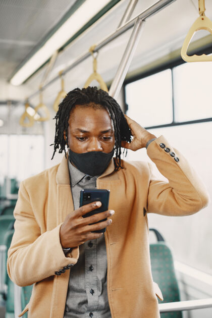公共汽车非裔美国人坐在城市巴士上穿棕色外套的家伙电晕病毒概念男人男子棕色