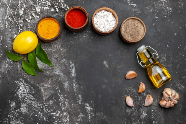 黑胡椒顶视图不同的调味品与油和柠檬上的深色表香料颜色胡椒容器香料挑选