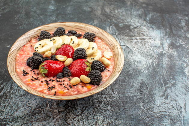 水果正面图：深色餐桌上水果切片的穆斯利健康早餐麦片健康食物膳食