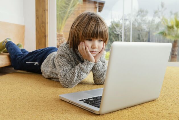 房子小男孩在笔记本电脑上看视频孩子男孩隔离