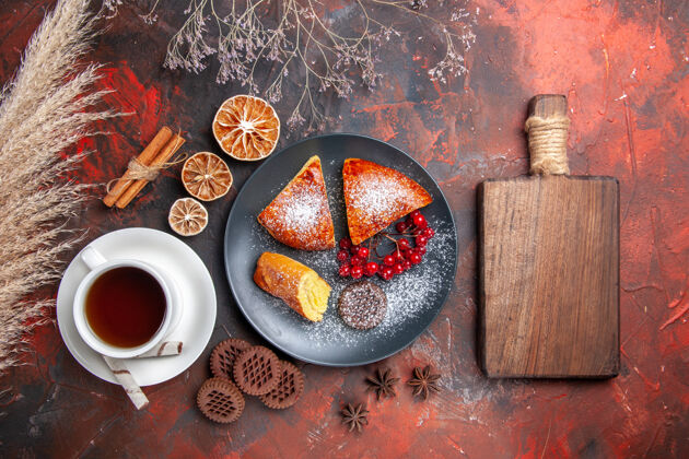 传统的俯瞰美味的切片馅饼配上一杯茶在深色的地板上蛋糕甜甜的馅饼茶坚果和螺栓热的蜡烛