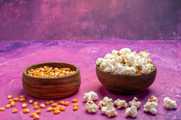 电影前视图新鲜爆米花与生玉米上浅粉色的表玉米电影电影的颜色生的新鲜处理