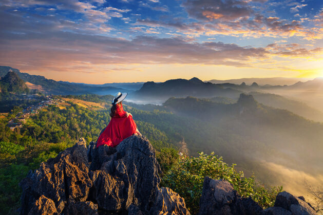森林美丽的女孩坐在日出的观点在贾波村 梅洪森省 泰国峰山谷季节