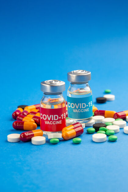 瓶子前视图：蓝色背景上不同药丸的小烧瓶中的疫苗罐子药品蓝色