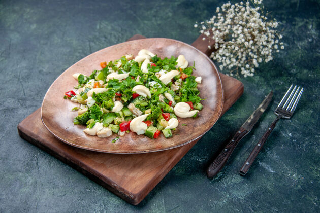 饮食前视图美味的蔬菜沙拉在深蓝色的背景与餐具盘子里晚餐沙拉正餐