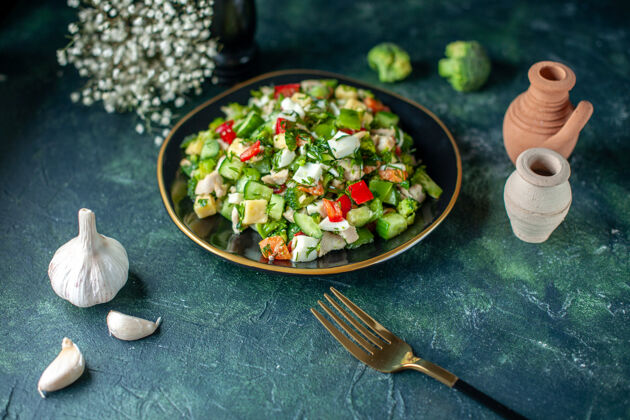 菜肴前视图蔬菜沙拉由深蓝色背景上的黄瓜奶酪和西红柿组成晚餐一餐饮食