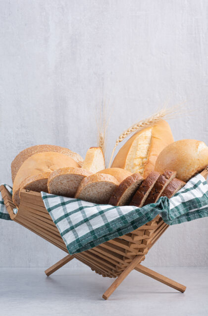 分类各式各样的面包放在大理石表面的篮子里法式面包食品面包