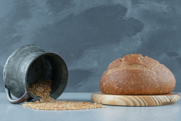 面包卷黑麦面包卷放在木板上 配上一大杯大麦营养马克杯黑麦