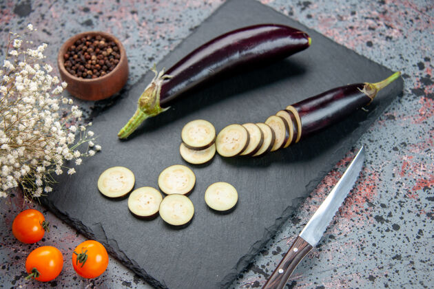 健康前视图黑色茄子切片和整个切菜板蓝色背景配料蔬菜茄子