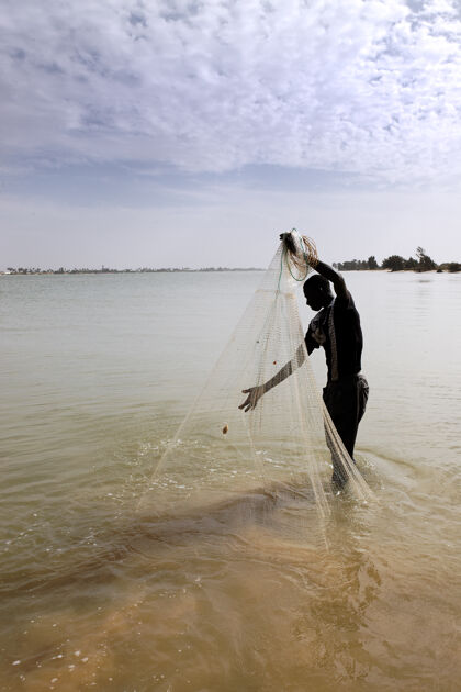 人河里有渔网的渔夫人非洲沙子