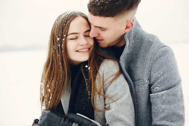 松树一对夫妇在雪林中散步的生活方式照片人们在户外度过寒假寒冷外面白天