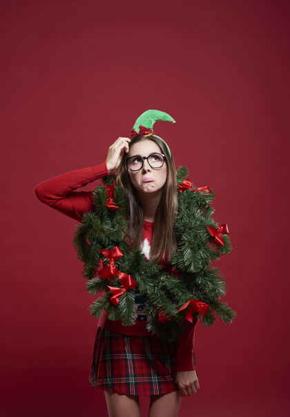 女人戴着圣诞花环的滑稽女人眼镜圣诞树沮丧