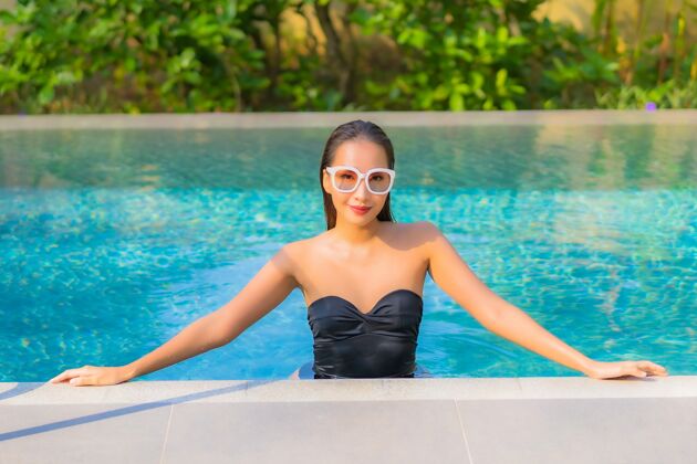 泳装美丽的亚洲年轻女子在游泳池里放松的画像度假放松年轻人