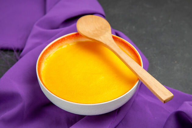 餐具正面图紫色纸巾上的简单南瓜汤健康勺子光滑