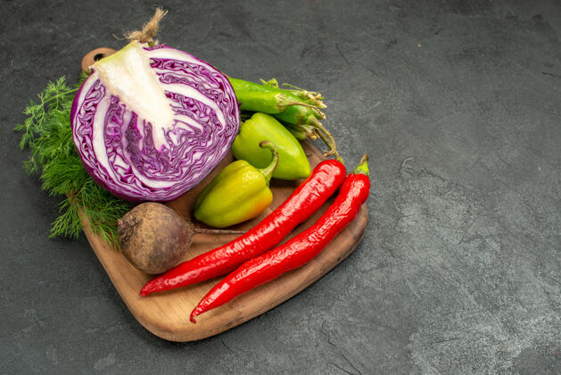 农产品前视图切好的红卷心菜和其他蔬菜放在深色餐桌上健康沙拉熟食健康甜椒素食