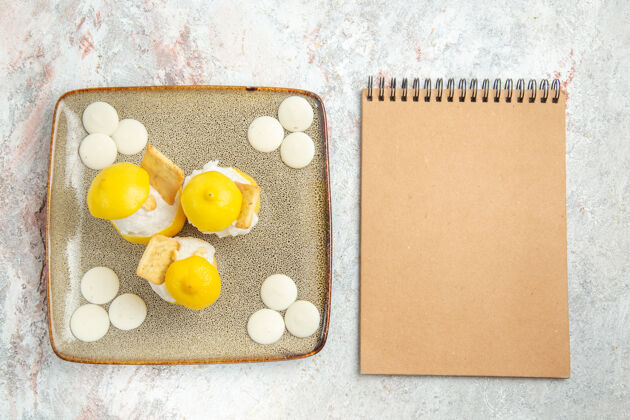 鸡蛋俯瞰柠檬鸡尾酒与白色糖果在白色的桌子上喝鸡尾酒果汁盒子水果纸板