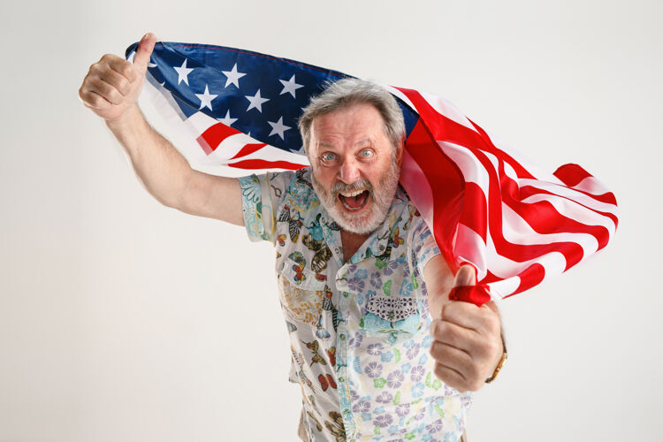独立拿着美国国旗的老人表情面部庆典