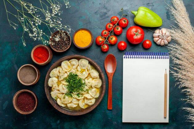 盘子俯瞰美味的饺子汤 不同的调味料放在深绿色桌上 肉汤蔬菜面团顶部风景西红柿