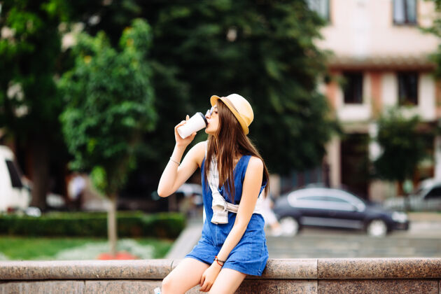 公园在喷泉边喝咖啡的年轻女人城市休闲城市