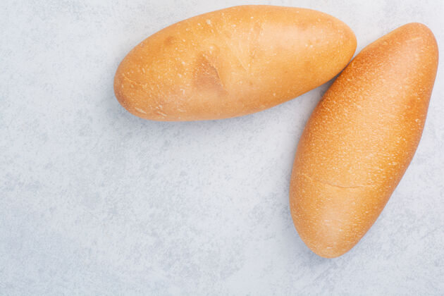 美味两个新鲜的面包放在石头表面混凝土白面包自制